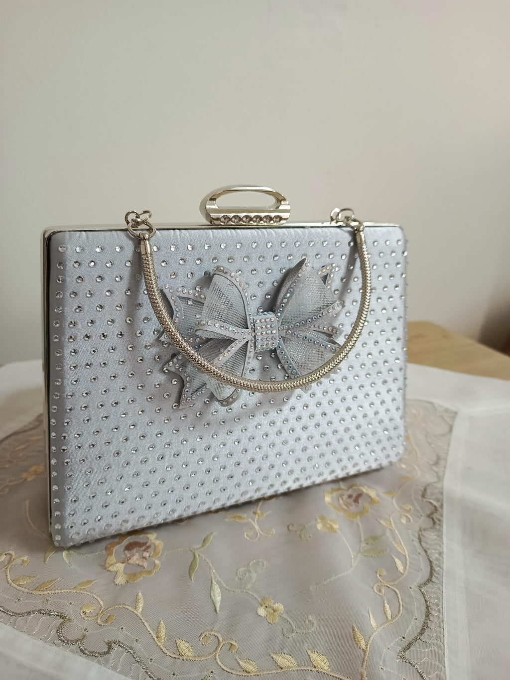 Silberne Abendclutch mit Schleifenverzierung