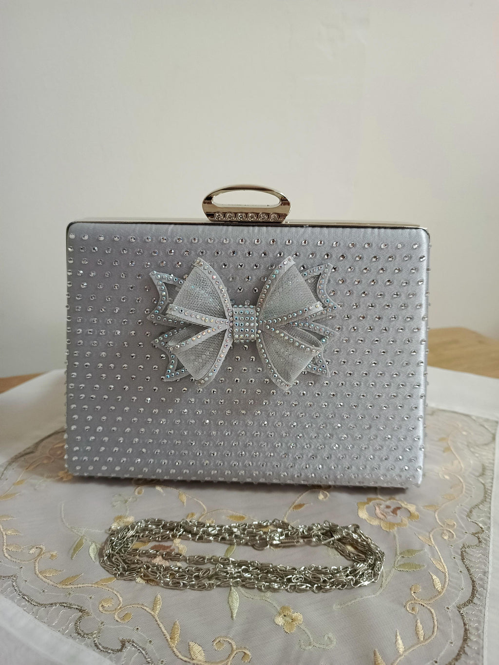 Silberne Abendclutch mit Schleifenverzierung